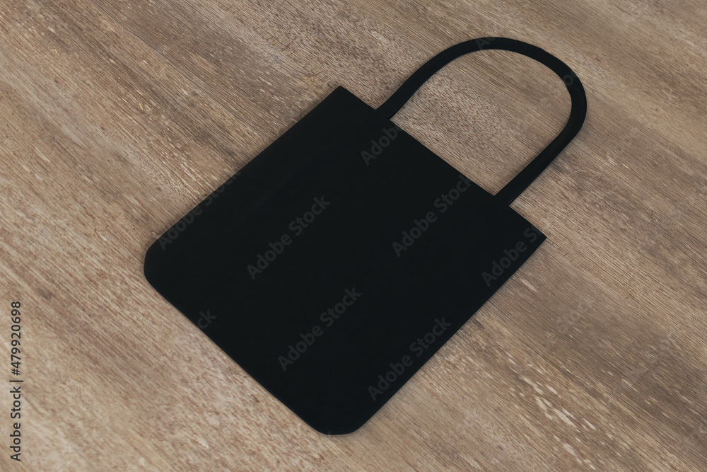 Poster top view and close up of clean black shopper on wooden table background. mock up, advertisement, 3d 
