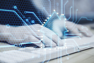 Close up of hands using keyboard with abstract glowing house chip hologram on blurry background. Smart home, ai and information concept. Double exposure.
