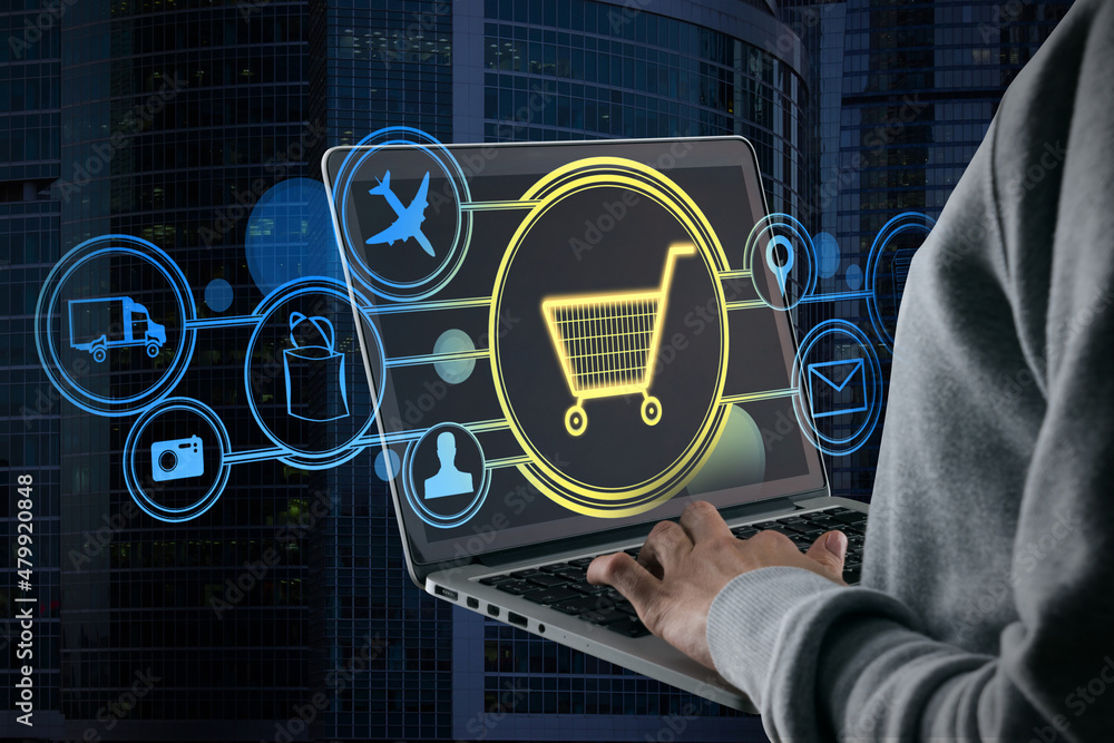 Poster close up of hand using laptop with abstract glowing cart interface on blurry city background. online
