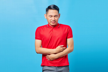 Portrait of sick young handsome Asian man with stomachache health problems diarrhea discomfort,...