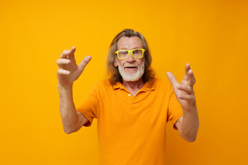 Naklejka premium Senior grey-haired man hand gestures emotions yellow glasses monochrome shot