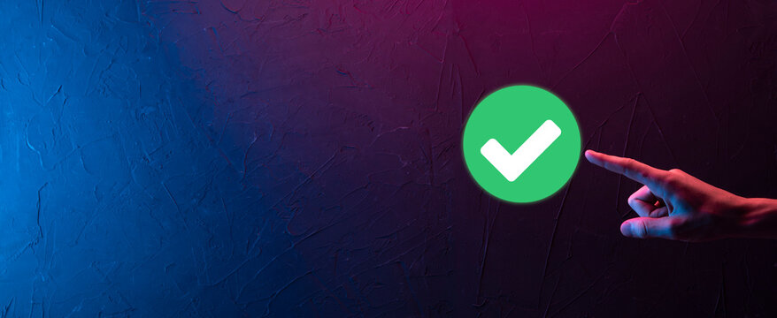 Hand holds green icon Check mark,Check Mark Sign, Tick Icon,right sign,circle green checkmark button,Done.On dark background.Banner.Copy space.Place for text.