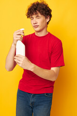 Young curly-haired man detergents home care posing isolated background unaltered