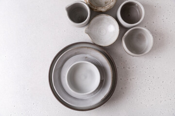 Handmade ceramic tableware, empty craft ceramic on a light background. Clay plates and cups.