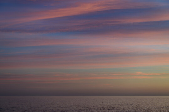 Atardecer con nubes coloridas en el mar Mediterráneo, en la Comunidad Valenciana. España. Europa