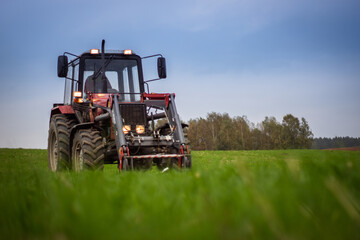 Tractor on a green field on a cloudy day © Rajmund Barnas