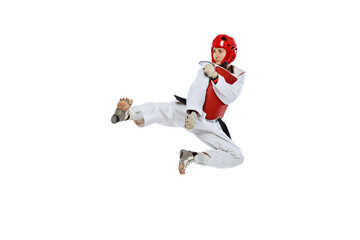 Young girl, taekwondo practitioner training, jumping isolated over white background. Concept of sport, skills