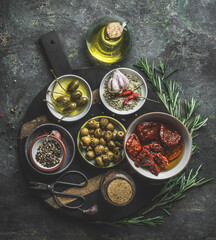 Various tasty Mediterranean food appetizer  in bowls : olives, capers, dried tomatoes , fresh...
