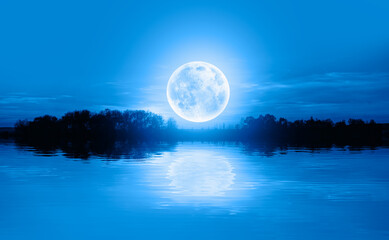 Fototapeta na wymiar Calm water of blue lake with full blue moon 
