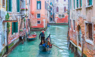 Venezianischer Gondoliere, der Gondel durch grüne Kanalwasser von Venedig Italien stochert