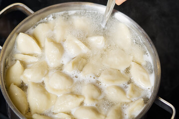 Meat Dumplings in boiling water. Meat dumplings are boiled in a pot of boiling water. Home fast food