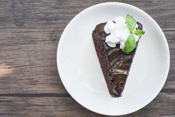 Closeup of chocolate cake in a plate on a wooden table