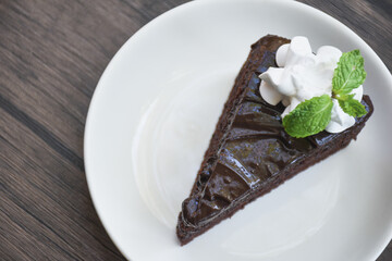 Closeup of chocolate cake in a plate on a wooden table