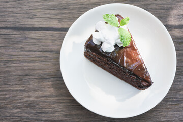 Closeup of chocolate cake in a plate on a wooden table