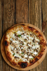 Delicious homemade pizza with mozzarella, mushrooms, beef and chicken. Wooden background, selective focus.