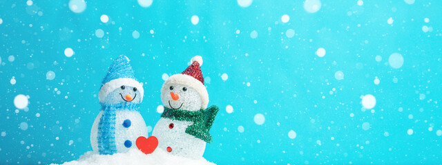 Winter snow snowman background panoramic banner panorama holiday greeting card - Little cute Snowman and red heart on snow in snowy landscape with snowflakes blue sky and sunshine