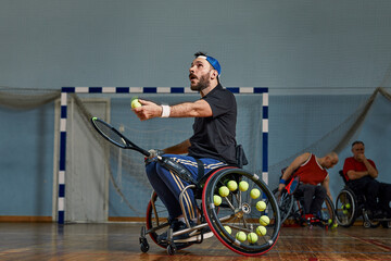 Young man in wheelchair playing tennis on court. Wheel Chair Tennis.