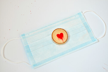 Pine tree slice with red blood heart symbol on blue medical mask. Valentines day wallpaper