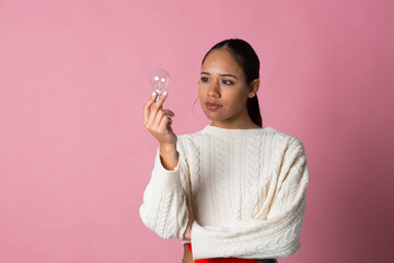 Young girl with an incandescent light bulb with high power consumption