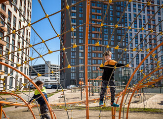 The children are playing on a playground in a school yard.