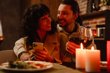 White couple using mobile phones during romantic date at home