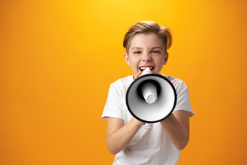 Little boy with megaphone on yellow background