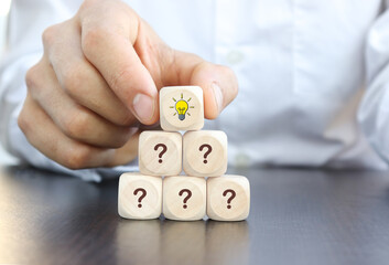 hand hold wooden cube Question mark and light bulb on wooden blocks lined up. Ideas, question mark ideas.