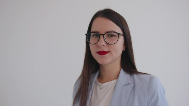 Portrait of a confident business woman with glasses on a white background. Leadership and success concept. Slow motion