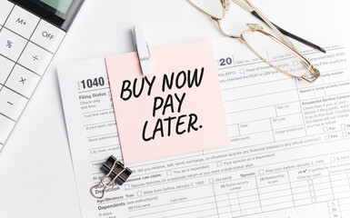 BUY NOW PAY LATER with pen, calculator, glass and sticker. Tax report sign