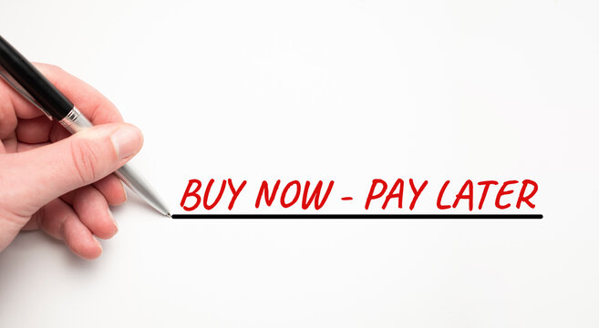 Hand writing BUY NOW PAY LATER with red marker. Isolated on white background. Business concept.