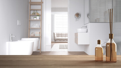Wooden table top or shelf with aromatic sticks bottles over modern white bathroom with sink and fixtures, parquet floor, white architecture interior design