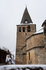 Obraz premium Romanesque church tower in a village. Winter photography with snowy landscape.