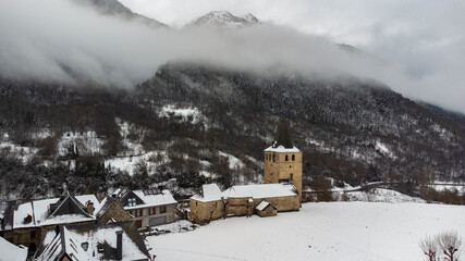 Romanesque church tower in a village. Winter photography with snowy landscape.