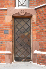Vertical shot of a vintage metal door on an aged church building with bricks 