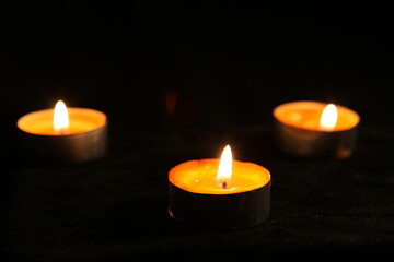 Obraz na płótnie Canvas three candles in the dark