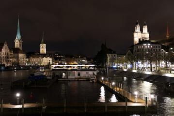 Obraz premium Cityscape of the old town of Zürich with protestant churches and river Limmat in the foreground on a rainy and snowy winter Friday night. Photo taken January 7th, 2022, Zurich, Switzerland.