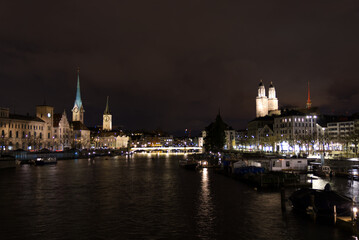 Cityscape of the old town of Zürich with protestant churches and river Limmat in the foreground on a rainy and snowy winter Friday night. Photo taken January 7th, 2022, Zurich, Switzerland.