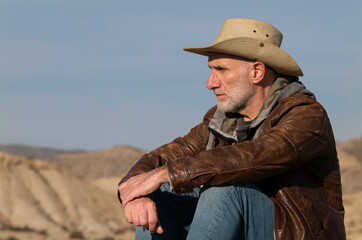 Adult man in cowboy hat looking at view of Tabernas Desert, Almeria, Spain