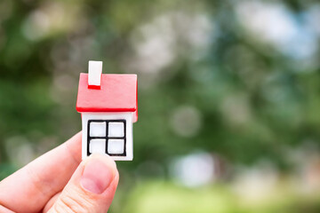 toy house with a red roof in nature. A symbol of mortgages, the concept of real estate, the purchase of new housing, happiness, family. Life in nature. space for copying. close-up. selective focus