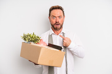 middle age man looking shocked and surprised with mouth wide open, pointing to self. unemployment...