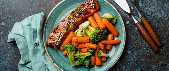 Grilled salmon fillet steak in teriyaki sauce with roasted vegetables carrot and broccoli on plate...