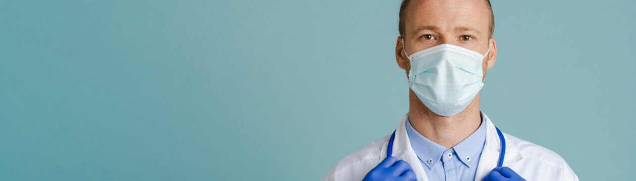 White Male Doctor Wearing Face Mask Posing With Stethoscope