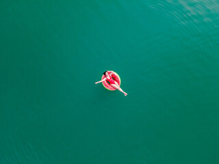 young happy woman floating in blue azure water on inflatable ring circle