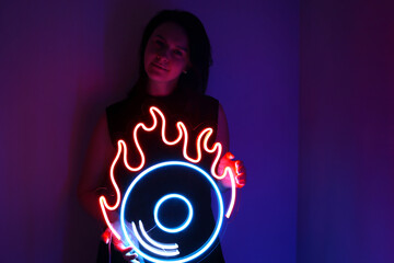 Beautiful girl with neon signs. Orange and blue neon vinyl record. Trendy style. Neon sign. Custom...