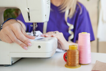 a woman sews on a sewing machine