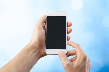Human hands showing smartphone against background.