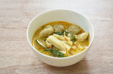 spicy boiled slice fresh coconut shoot with fish ball in green curry soup on bowl