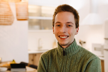 Obraz premium European ginger man smiling and looking at camera in home