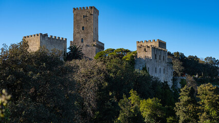 Fototapeta na wymiar Erice, Sicily, Italy. Glimpse of Venus Castle with trees and blue sky