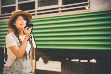 Asian young girl taking photo, happy traveler by the train